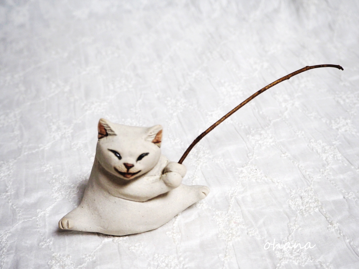 釣り竿を持つ白猫